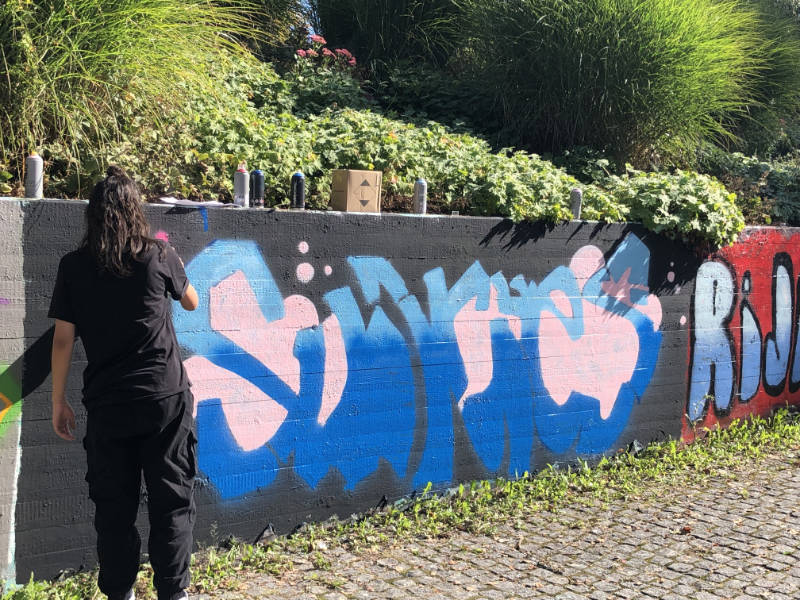 Eine mit fantasievollen Buchstaben in bunten Farben besprühte Mauer im Stadtpark