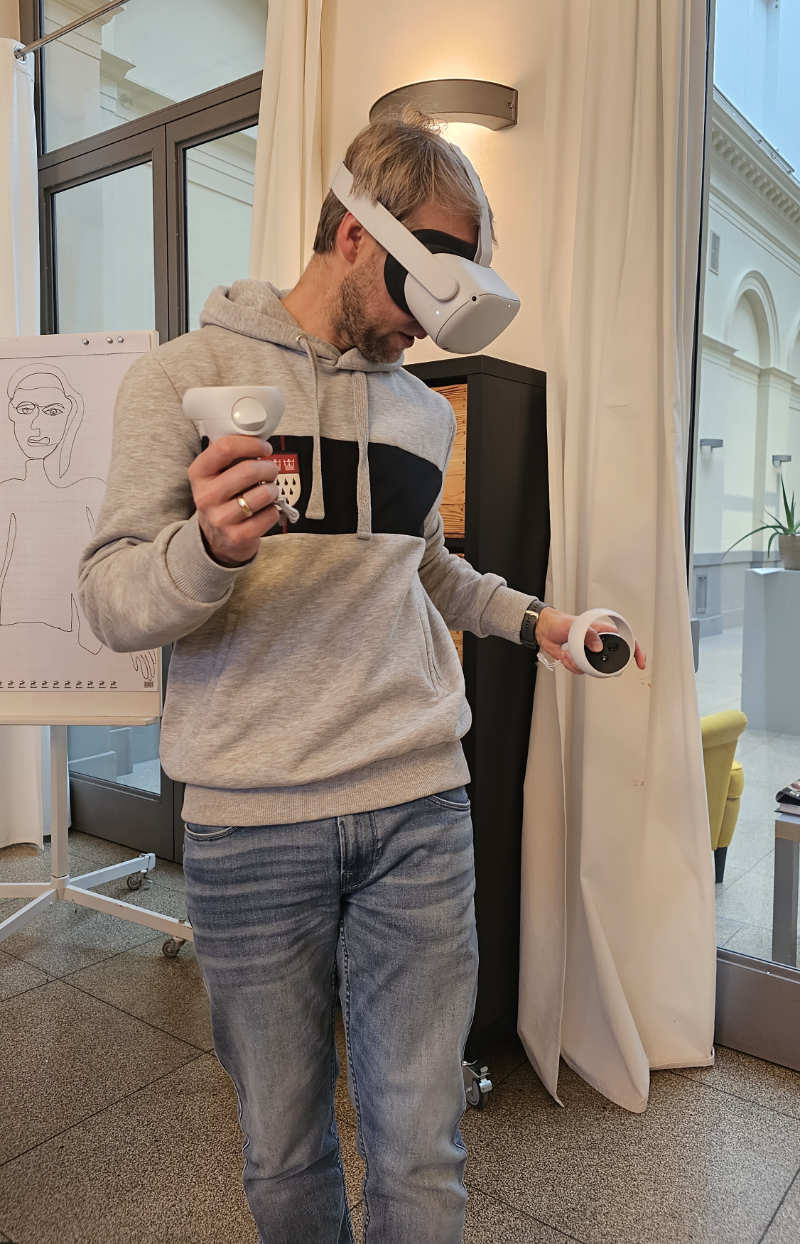 Eine Person schaut sich mittels einer VR-Brille im viruellen Raum um