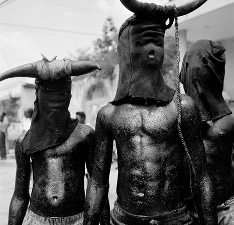 Schwarz-weiß-Fotografie mit zwei Personen, die Masken mit Hörnern tragen