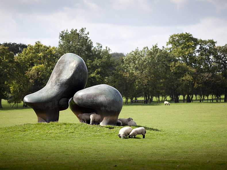 große abstrakte Skulpturen auf einem weitläufigen Rasen von Schafen umringt