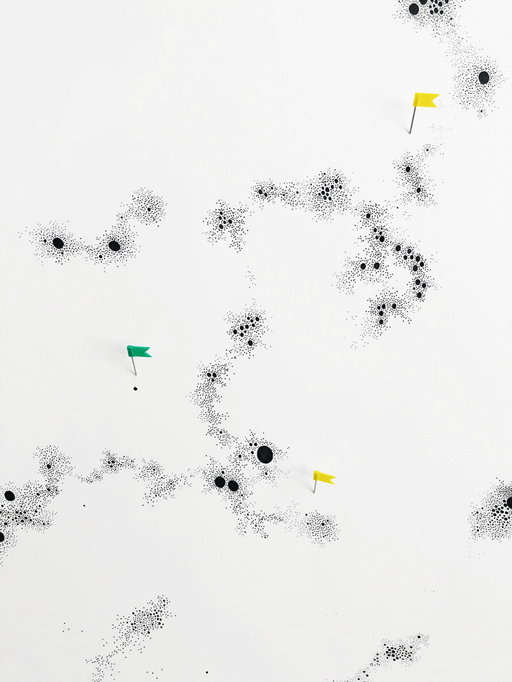 mehrere Wolken kleiner schwarzer Punkte auf weißem
            Papier, dazwischen kleine grüne und gelbe Fähnchen wie auf
            einer Landkarte